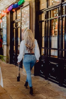 British blonde in jeans walking by a shop