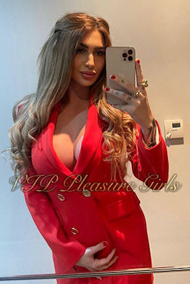 Hot busty blonde in a red jacket looking ready for a night out