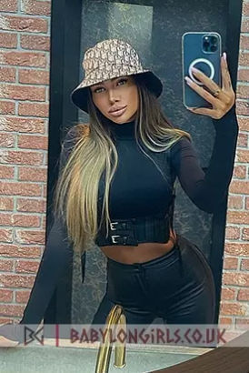 Busty Czech girl in a Kangool hat and tight black trousers taking a selfie