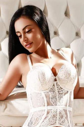 Very young and busty Brazilian girl in white lingerie leaning back and smiling