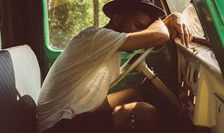 Young guy slumped over the steering wheel of his car