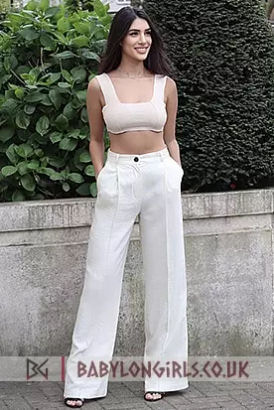 Chic, stylish woman in white trousers and a crop top