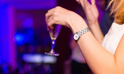 A blonde woman holding a glass of bubbly