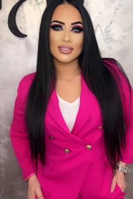 Greek girl with long dark hair in a bright pink blazer
