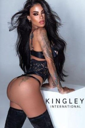 Tattooed black hair woman in a black thing posing