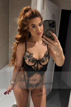 Cute Romanian girl with big hair taking a selfie in a bathroom