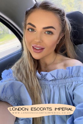 Very pretty young blonde girl taking a selfie in a car